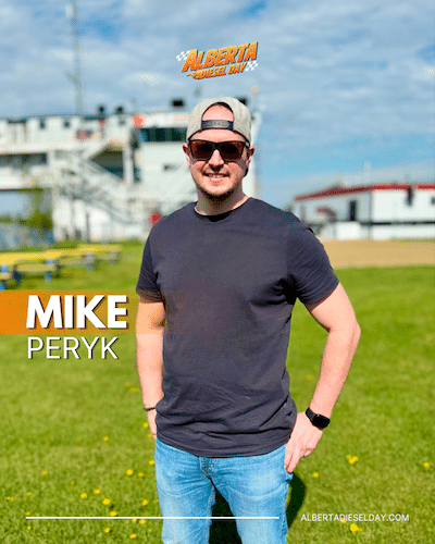 Portrait of Mike Peryk standing on a sunny grassy field with a stadium in the blurred background; his name appears in bold on the left with the Alberta Diesel Day logo above.