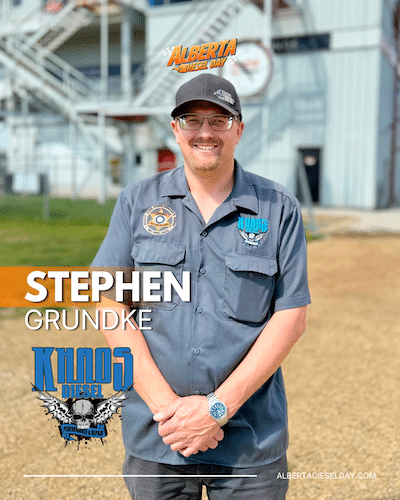 Portrait of Stephen Grundke standing outdoors at a diesel event, smiling in a gray shirt with patches and cap.